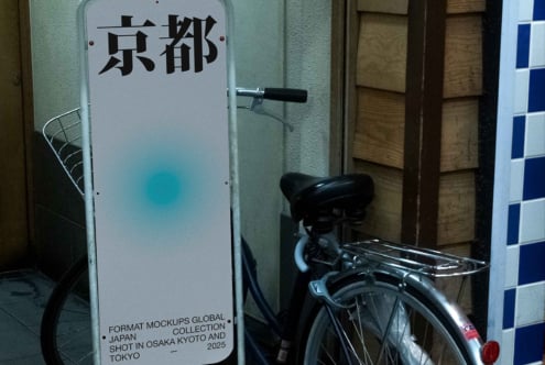 Illuminated standing sign with Japanese text mounted on street level