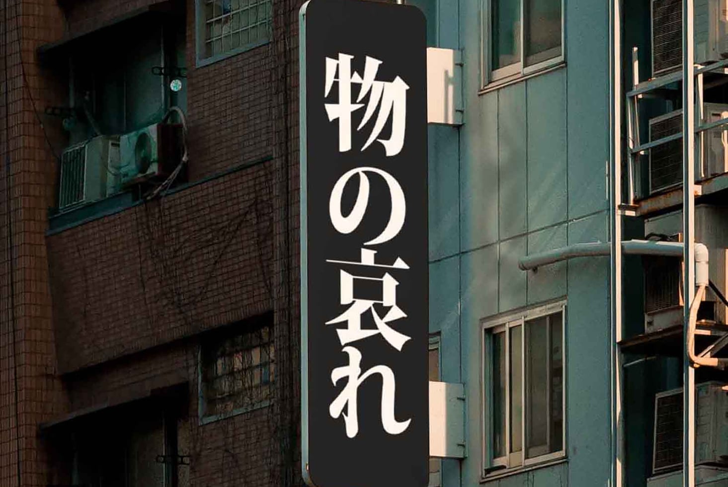 Vertical black signage with white Japanese characters on city street