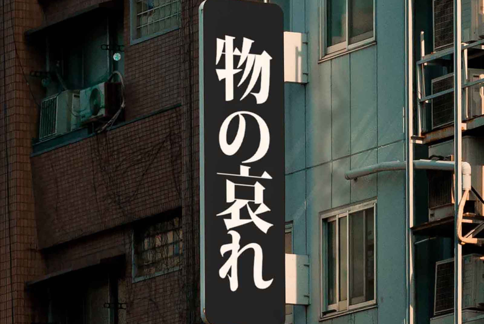 Vertical black signage with white Japanese characters on city street