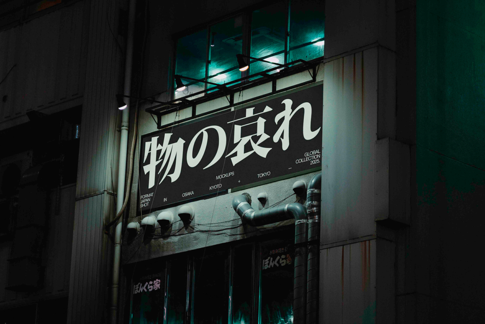 Glowing storefront sign displaying Japanese text on dark urban building