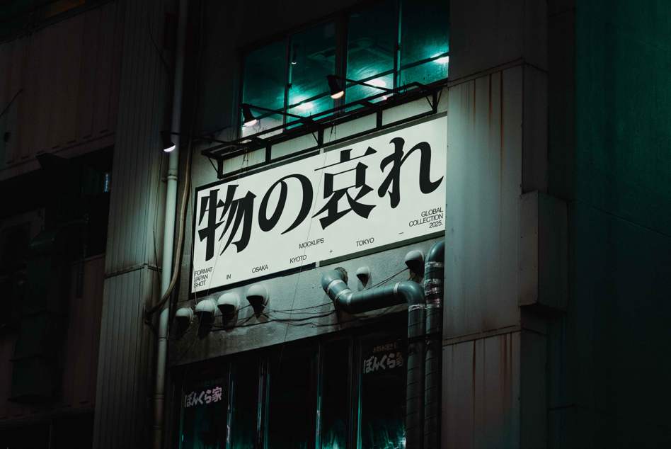 Nighttime shot of illuminated street sign with Japanese characters in Osaka