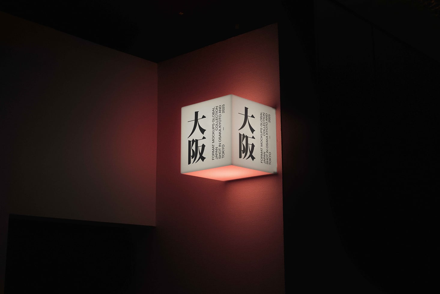 Cube-shaped corner sign with Japanese characters on cream panels, warm coral interior glow