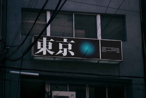 Horizontal illuminated sign with kanji showing cyan glow effect at night