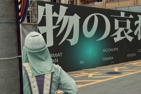 Large billboard with white kanji characters fading to teal gradient, character in foreground