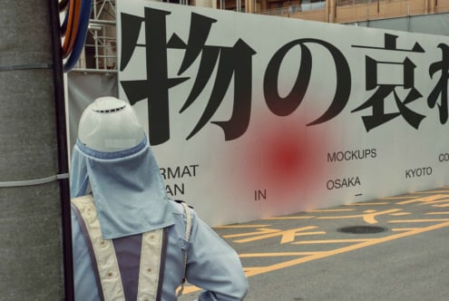Wide signage with kanji text transitioning from white to pink glow, figure below