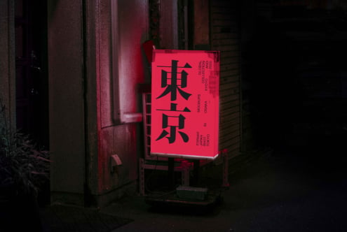 Bright neon pink box sign with bold black kanji characters in dark alley