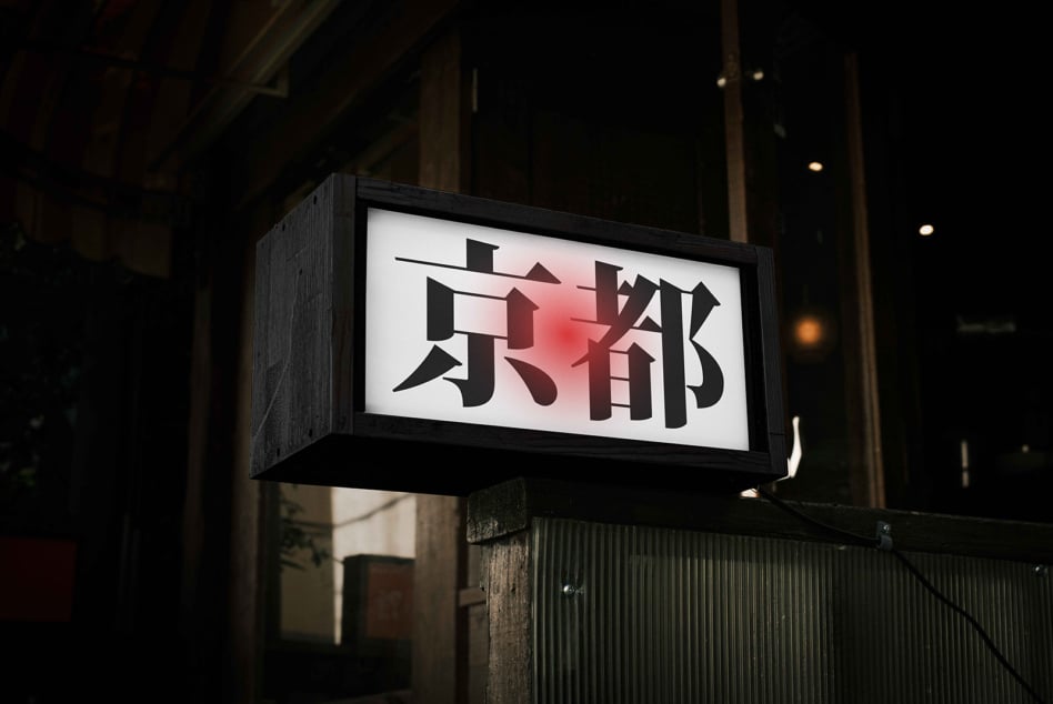 Nighttime illuminated sign with black kanji on white light and red gradient accent