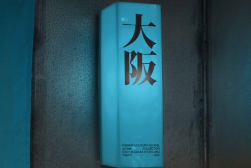 Cyan blue tall box with black kanji characters on textured concrete backdrop