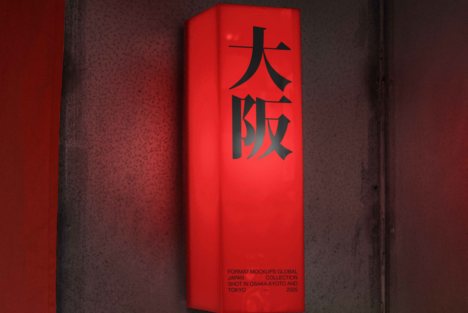 Bright red tall box with black kanji characters on textured concrete backdrop