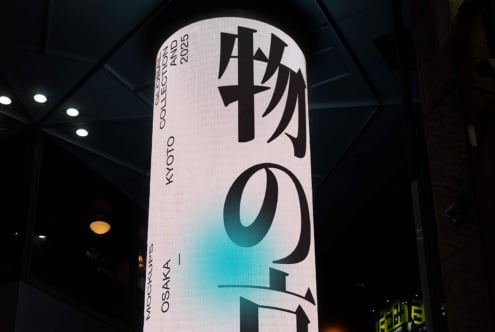 Illuminated cylindrical display with teal gradient, kanji characters visible