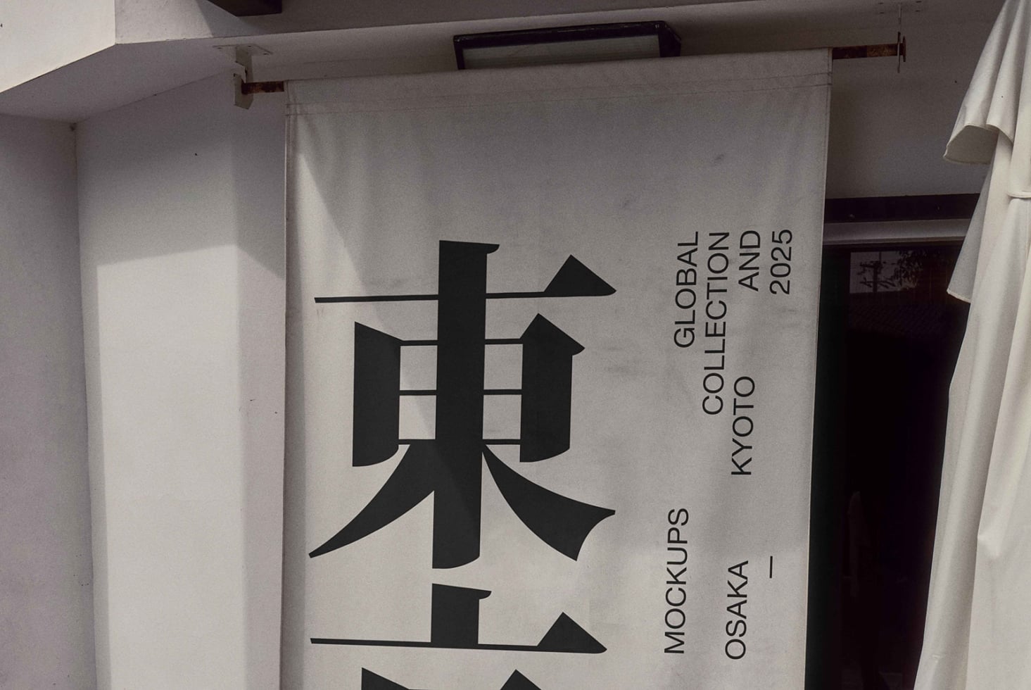 Hanging fabric banner mockup with bold black kanji design, Kyoto backdrop
