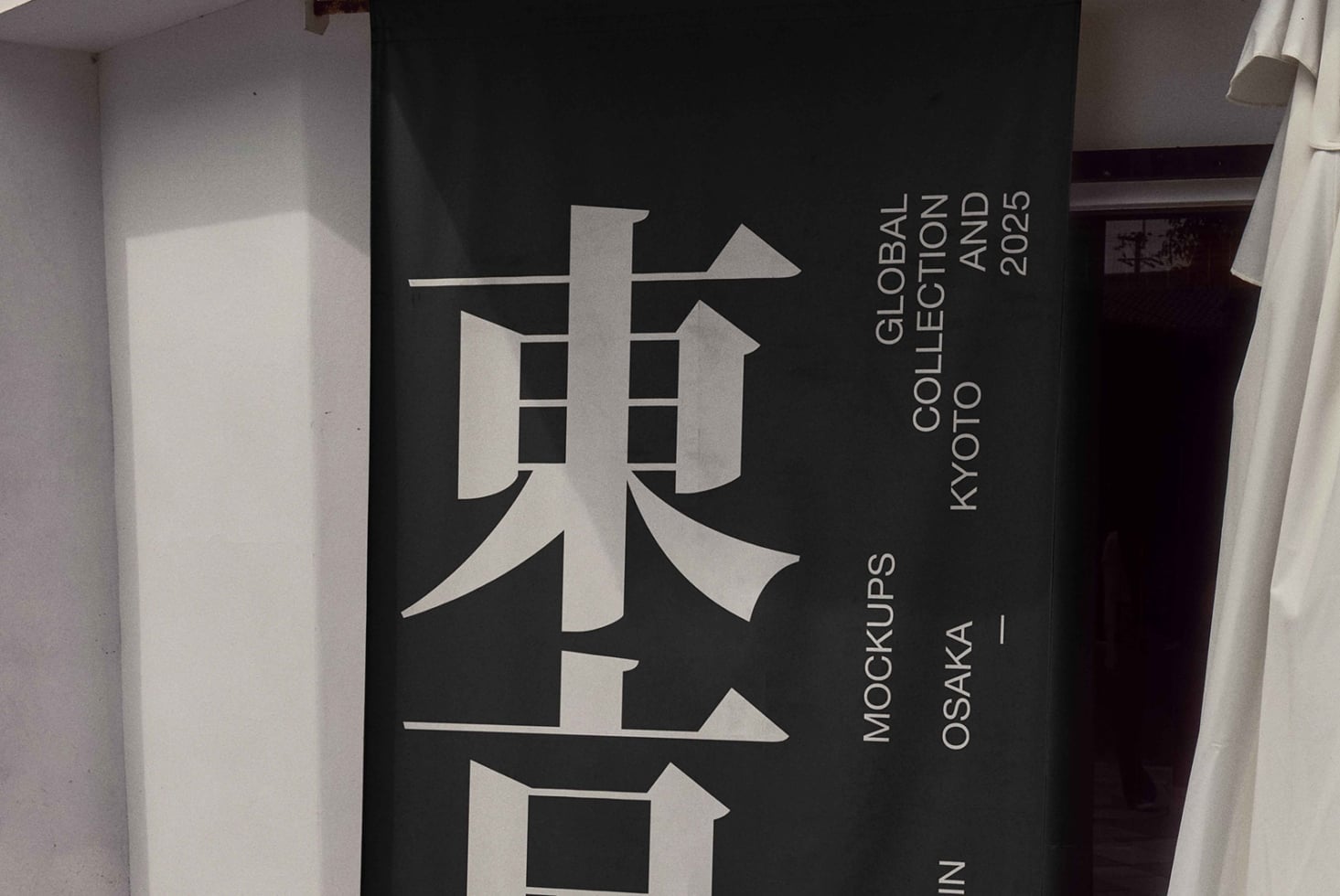 Dark cylindrical banner mockup with white Japanese typography, Osaka location