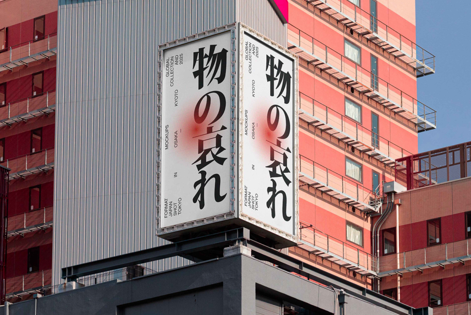 Double-sided sign with Japanese characters against coral colored building backdrop