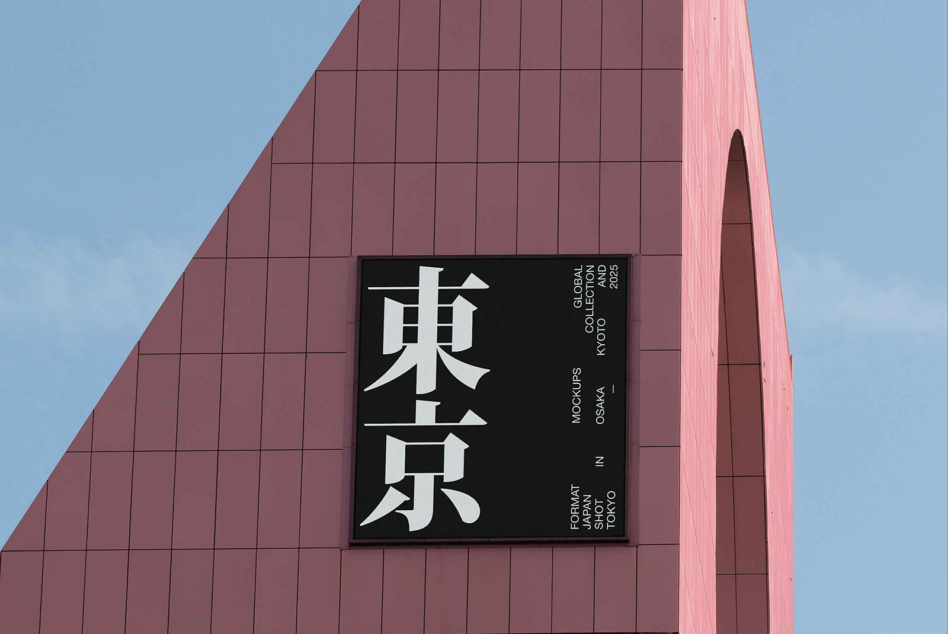 Black sign displaying white Japanese kanji on mauve colored architectural structure
