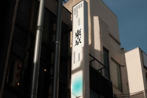 Building-mounted vertical banner featuring kanji text displayed in daylight