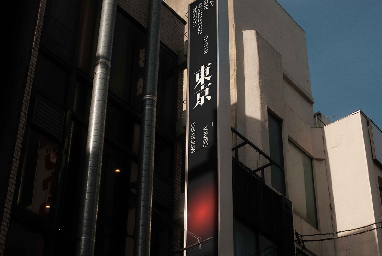 Dark vertical signage with white text showing Japanese characters lit at night