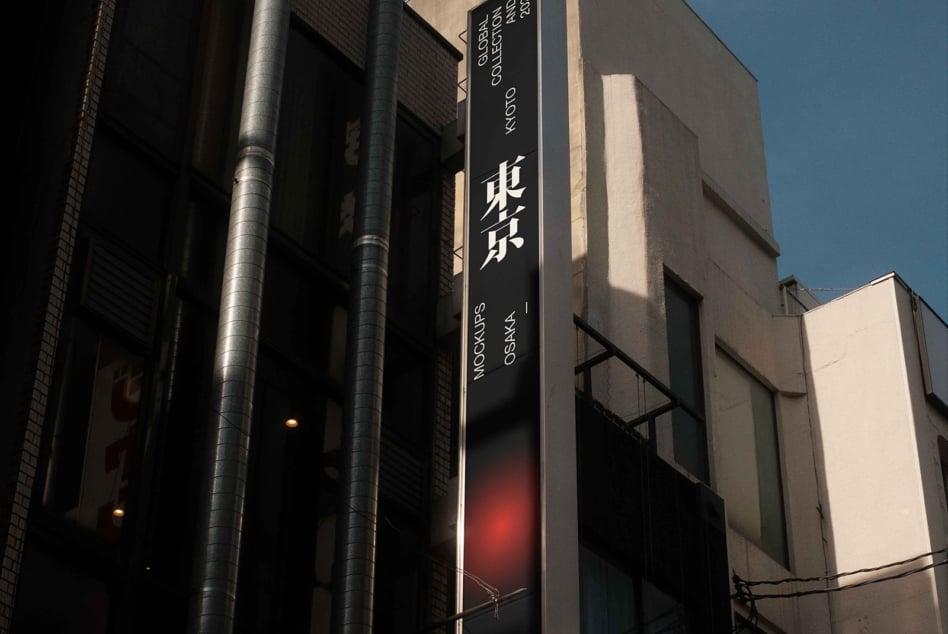 Dark vertical signage with white text showing Japanese characters lit at night