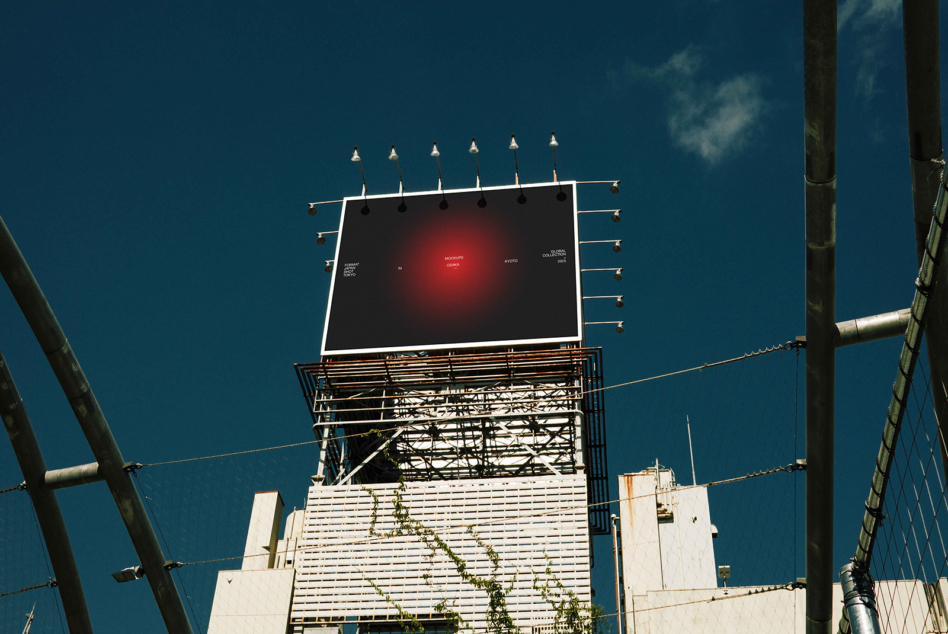 Vintage rooftop billboard with red glowing center against deep blue sky
