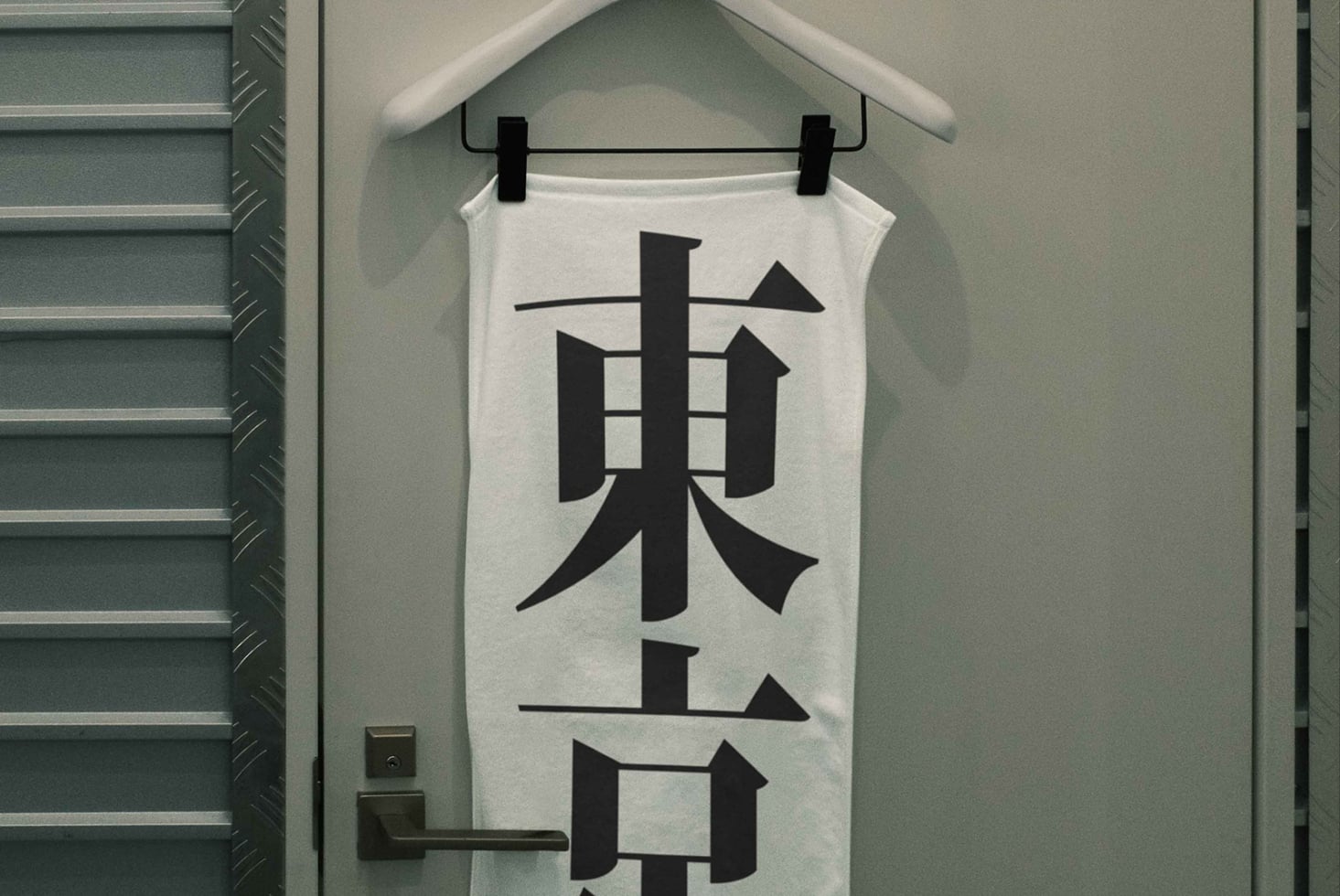 Sleeveless white shirt on hanger with large black kanji design centered