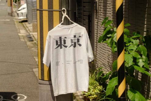 White crewneck shirt with black kanji lettering on urban alley background