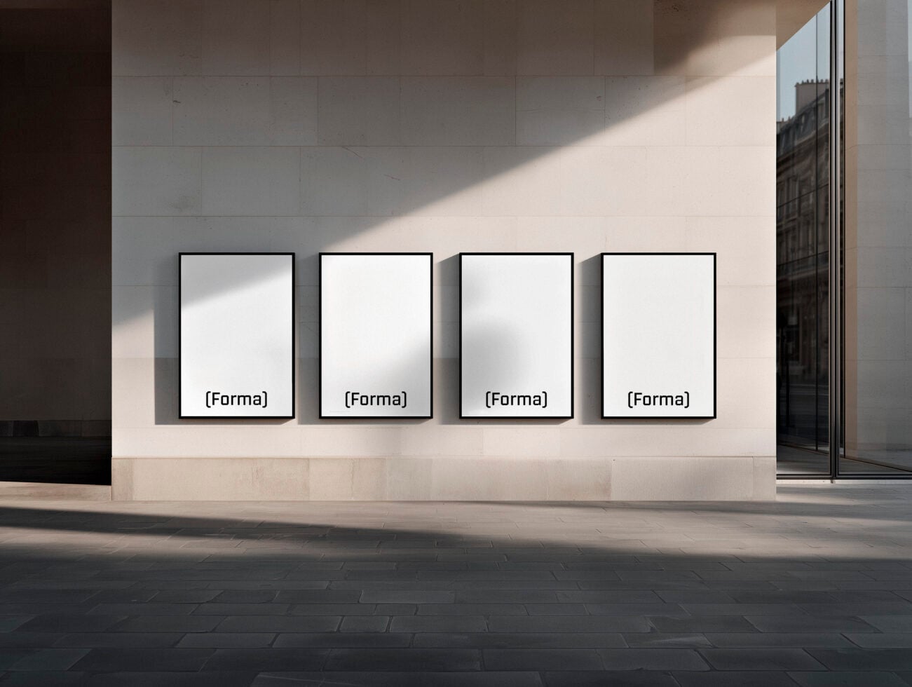 Four blank framed posters on white gallery wall with natural light