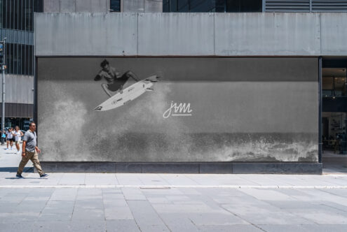 Large outdoor billboard mockup showing surfer riding wave in black white