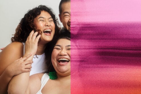 Three people laughing together against pink gradient fabric backdrop