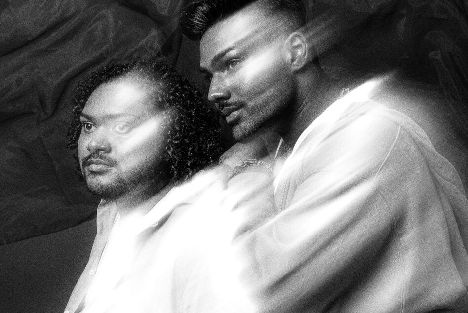 Black-white intimate portrait of two men in close proximity, soft dramatic lighting