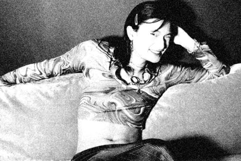 Black-and-white portrait of person lying down with headphones around neck