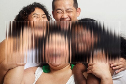 Couple holding corrugated glass panel with motion blur streaks obscuring their eyes