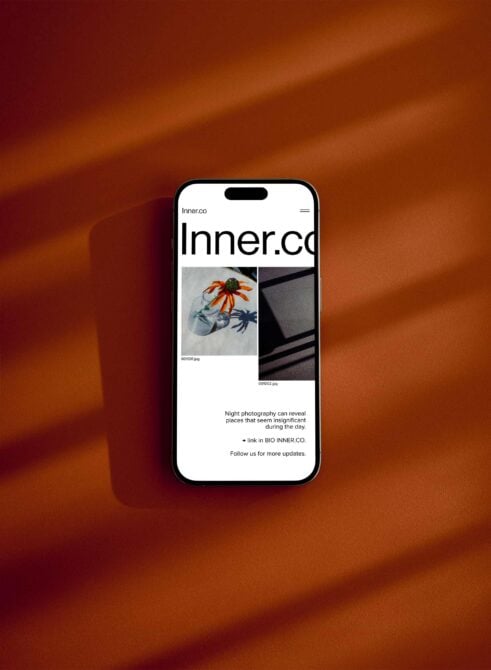 iPhone on burnt orange background displaying Inner.co portfolio with gallery grid layout