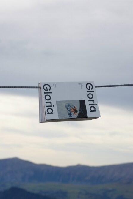 Magazine hanging on wire against sky showing Gloria publication cover mockup