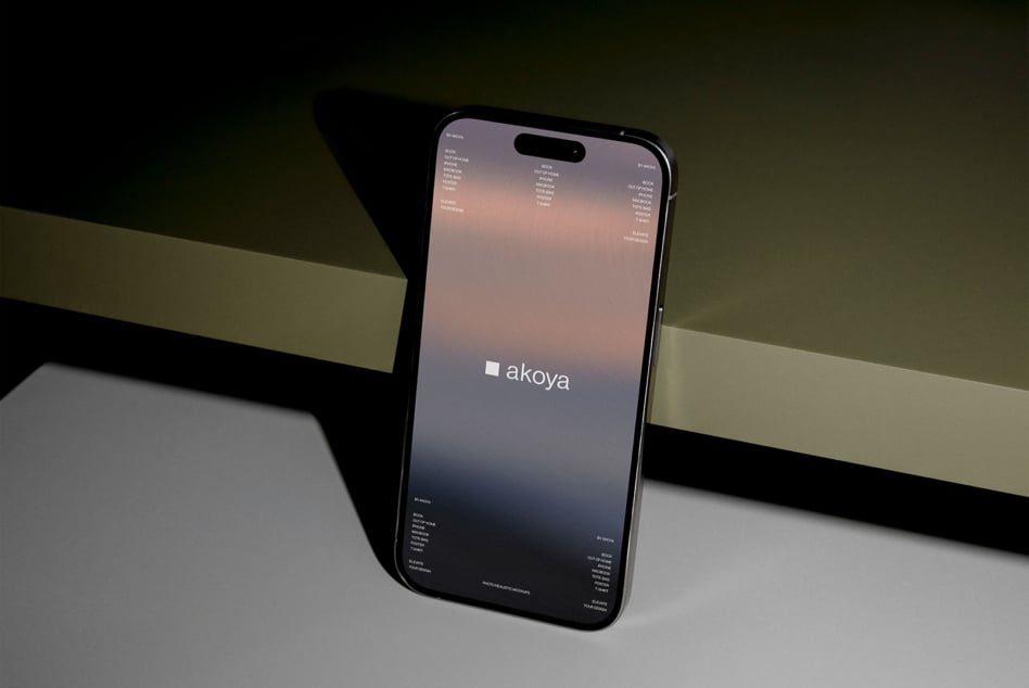 iPhone on split-tone background showing Akoya brand website with gradient overlay