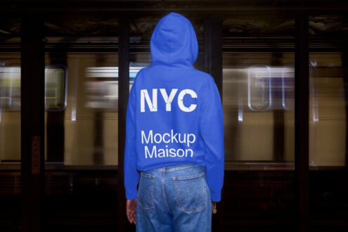 Person wearing bright blue hoodie from behind standing in subway station