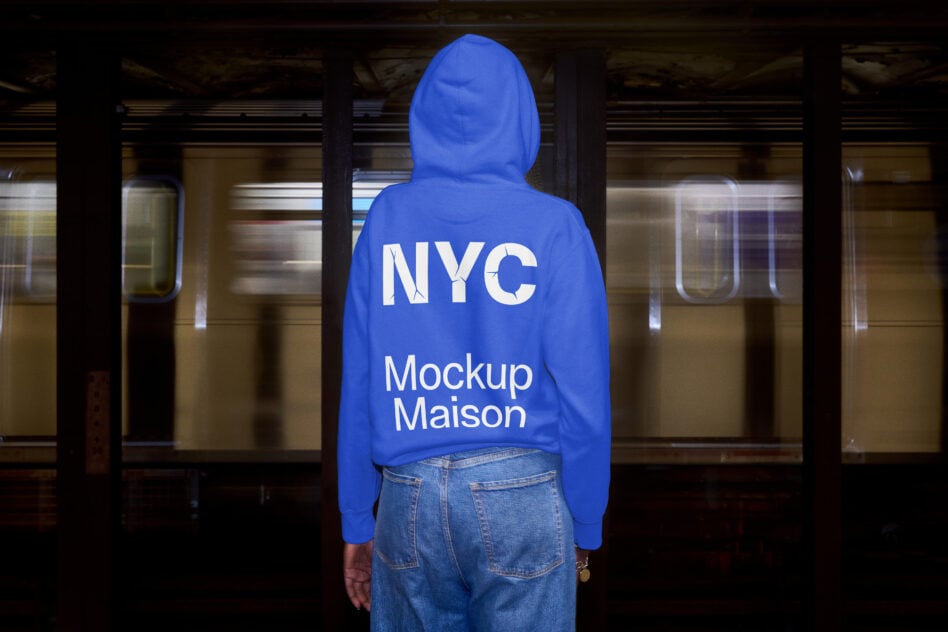 Person wearing bright blue hoodie from behind standing in subway station