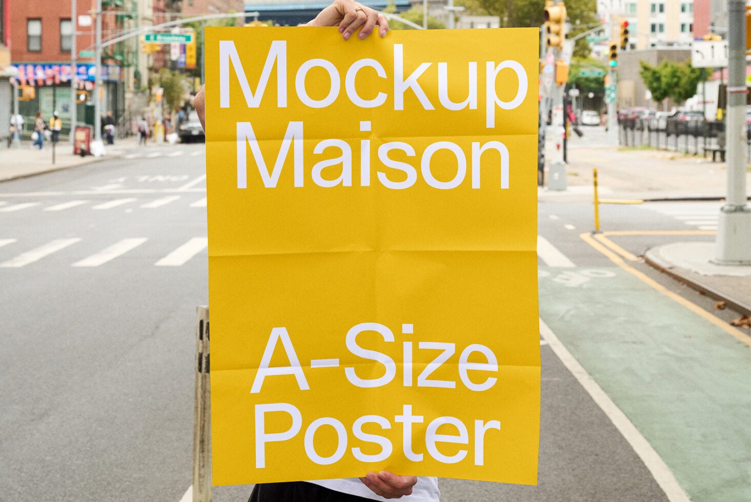Yellow A-size poster mockup held up on downtown street with traffic lights