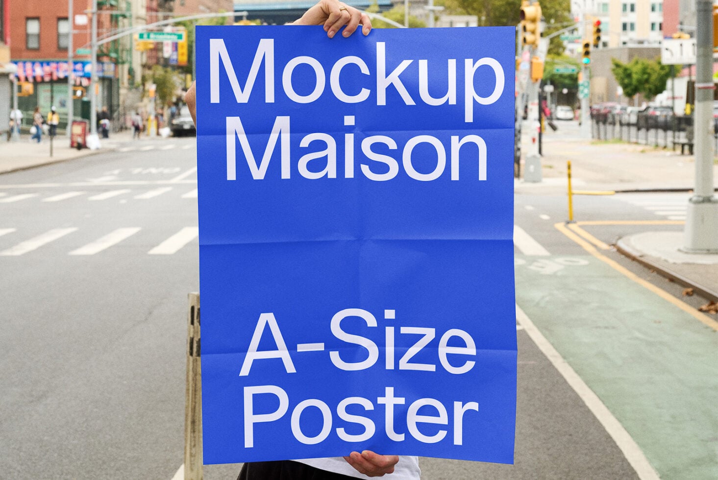 Blue A-size poster mockup displayed on urban intersection with pedestrians