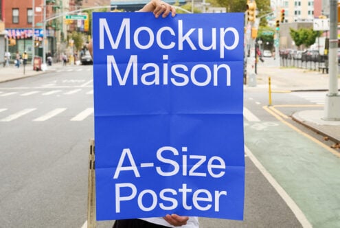 Blue A-size poster mockup displayed on urban intersection with pedestrians