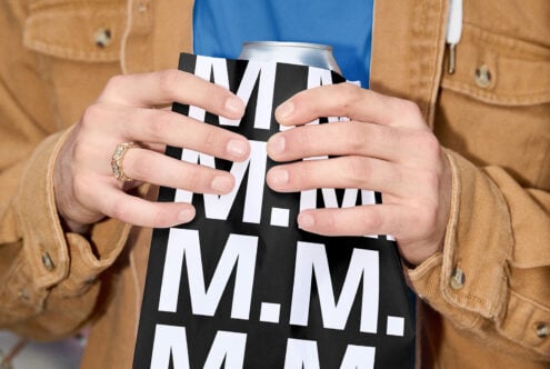 Hands holding aluminum can with black white geometric pattern design