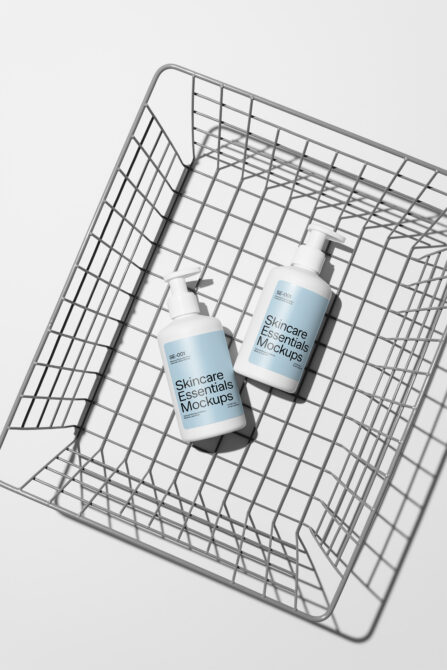 Two pump bottles inside metal wire shopping cart on white background