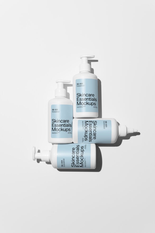 Four cosmetic bottles in different shapes with Skincare Essentials Mockups branding