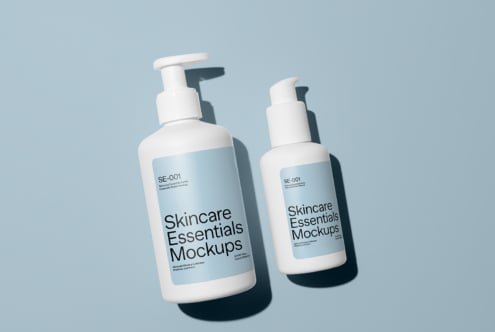 Two pump bottles with shadows on soft blue background