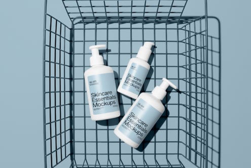 Three pump bottles inside shopping cart on blue background