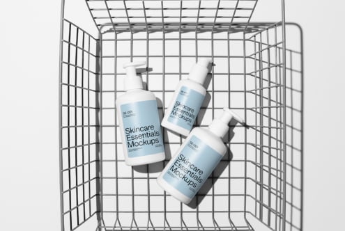 Three pump bottles inside shopping cart on white background