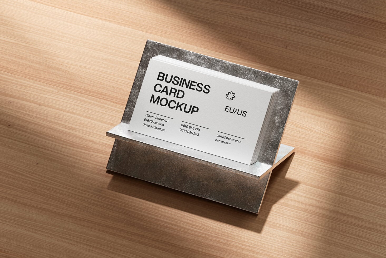 Business card stack in grey metallic holder on wooden surface