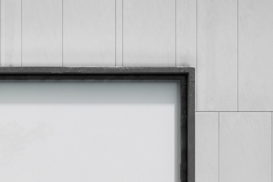 Close up of dark metal frame corner on textured white panel wall