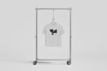 Light grey tee on rolling rack with abstract leaf graphic design