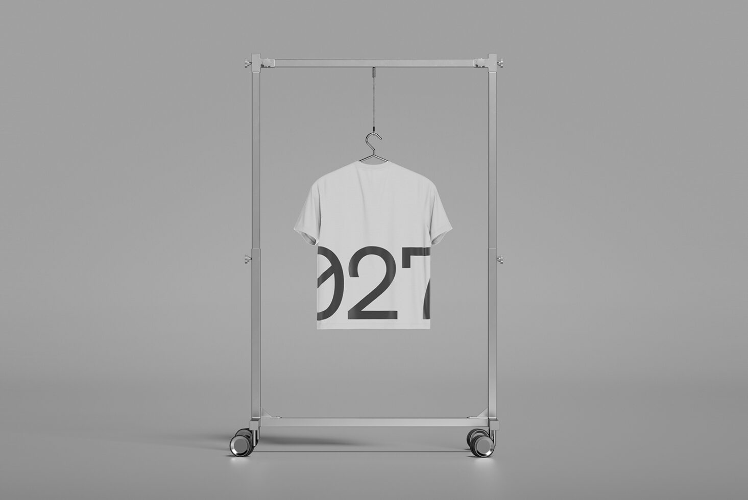 T-shirt mockup hanging on metal frame rack with partial text visible on garment