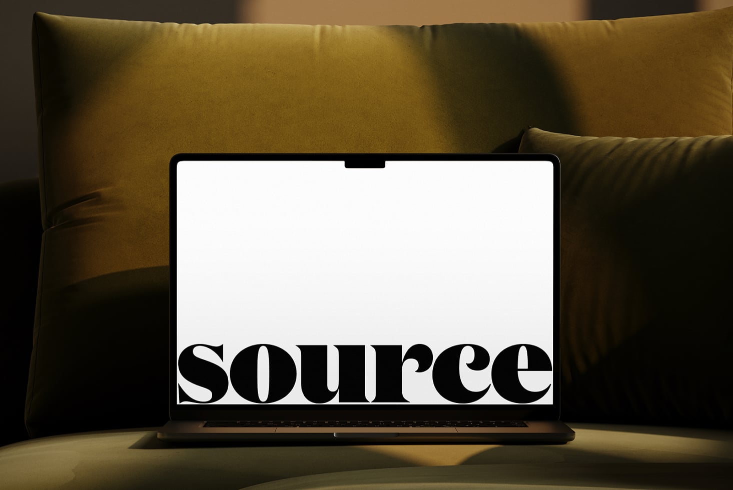 MacBook between velvet pillows showing serif typography mockup