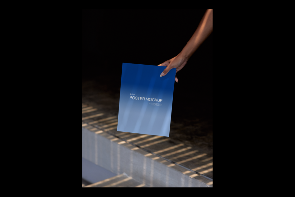 Person holds a blue poster mockup with shadows and reflections on a modern background. Ideal for showcasing poster designs. Perfect for graphic designers.
